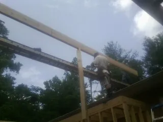 Carpenter setting a ridge beam over a new addition frame — Ice Dam Removal by Roofing Brothers in Spartansburg
