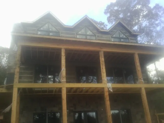 Dormers and porch framing on a large log home under construction — Roof Coating work by our crew in Spartansburg