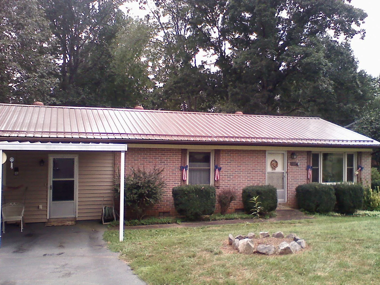 Bronze metal roof and carport on a brick ranch home — Roof Repair work by our crew in Spartansburg